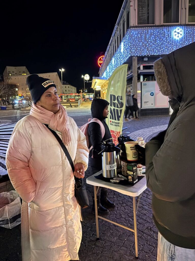 Person i samtal med en RSMH-strandflagga i bakgrunden